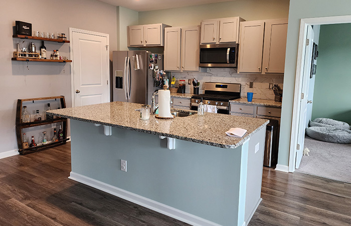 JBG Painting interior project with updated gray cabinets, granite countertops, and repainted walls for a fresh modern look.
