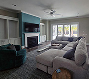 JBG painting project featuring a modern living room with teal accent wall, fireplace, and large sectional sofa.