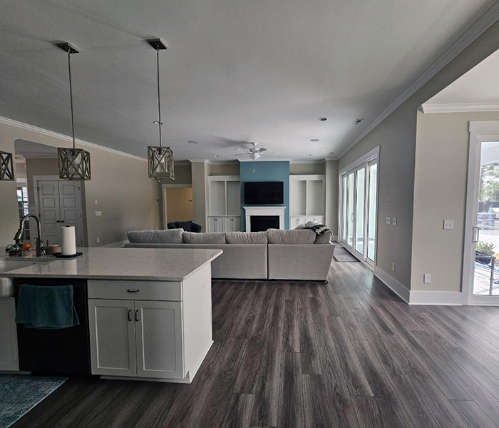 Open concept kitchen and living room with modern island and hardwood floors.