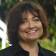 Billie, part of the JBG Painting team, smiling outdoors in a professional headshot with a blurred natural background