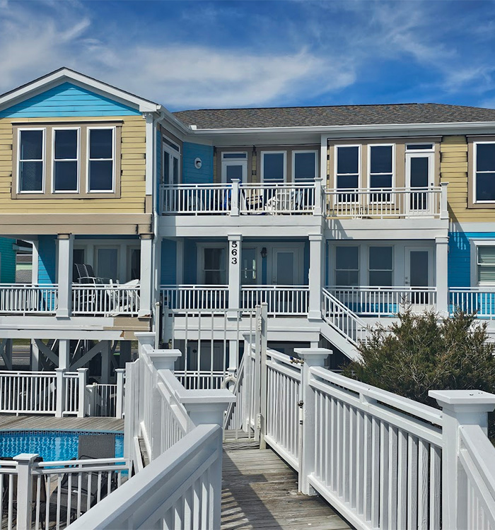 JBG Painting exterior project showing fresh yellow and turquoise coastal home paintwork.