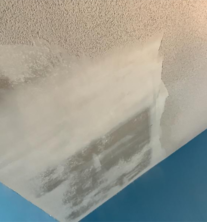Close-up of popcorn ceiling removal and skim coating in progress – JBG Painting.