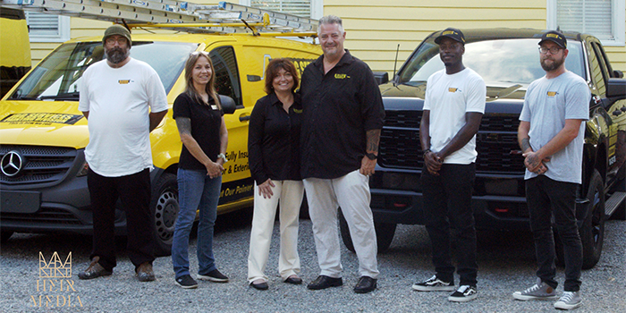 Group photo of JBG Painting crew with branded vehicles in Wilmington NC.